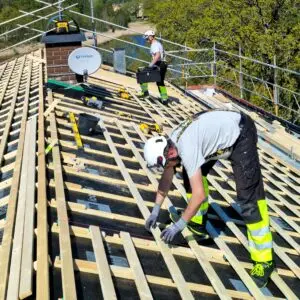 Snickeriarbeten vid takbyte i Karlskrona – montering av takläkt och exakt höjdjustering inför installation av Lindab profilerad plåt.